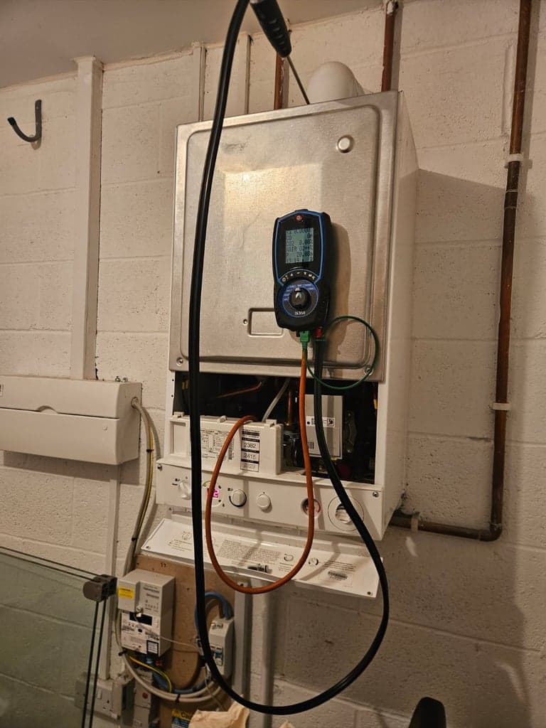 Flue gas analyser testing during a Potterton boiler service in a garage in Totnes